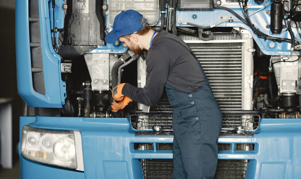 Man with tools for truck. Worker in uniform. Faulty truck